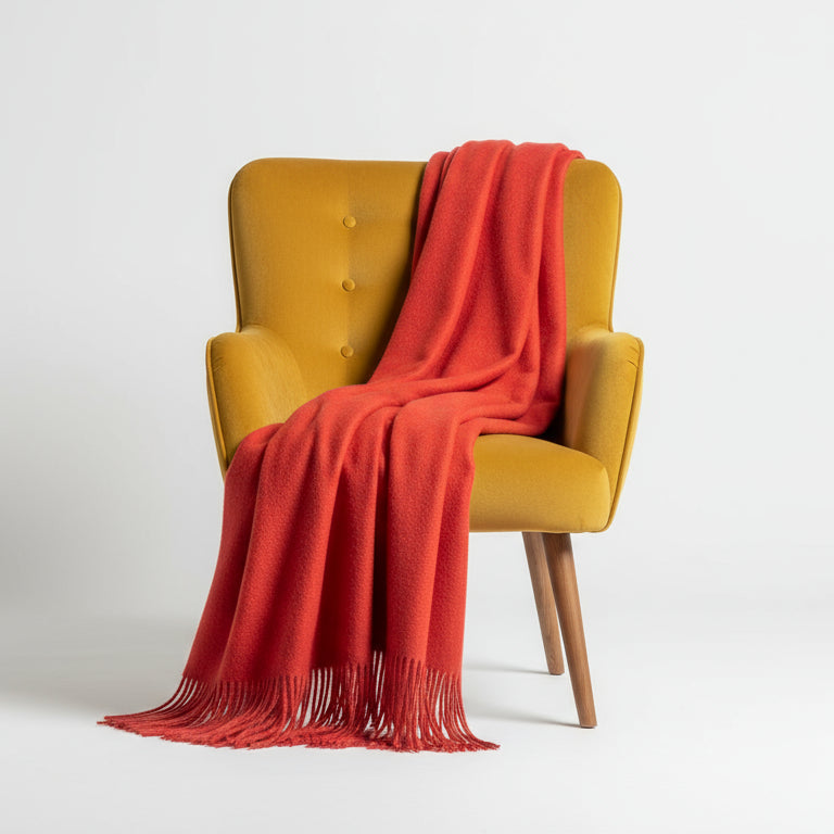 Yellow armchair with a red blanket draped over it on a white background