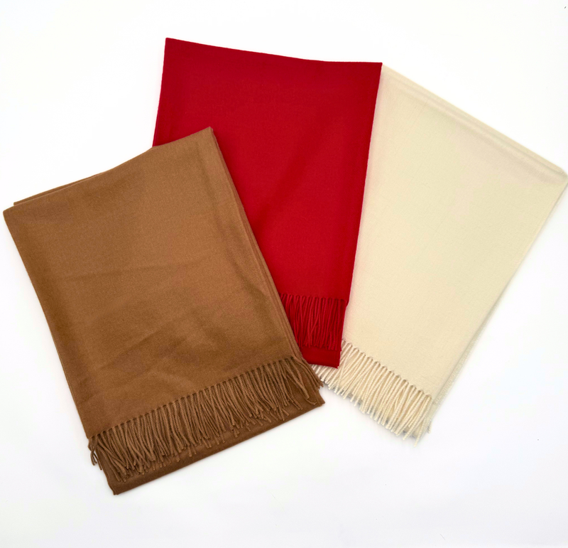 Three scarves in brown, red, and beige on a white background