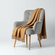 Gray chair with a brown blanket draped over it on a white background baby alpaca