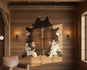 A large, irregularly shaped bison rug with a patchy brown and white pattern, displayed on a plain background.